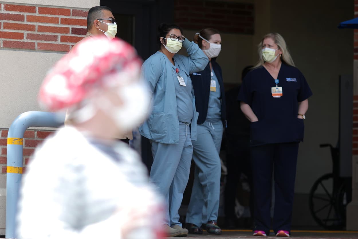 Image: Nurses stand in a hospital doorway watching a nurses?EUR(TM) protest for personal protective equipment at UCLA Medical Center, as the spread of the coronavirus disease (COVID-19) continues, in Los Angeles