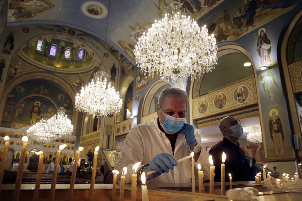 Image: A worshipper lights a candle during Sunday mass at the Saint Nicolas Church in Beirut, Lebanon, on May 10, 2020. Lebanese churches reopened for the first time in almost two months as social restrictions to curb the spread of coronavirus were loosen
