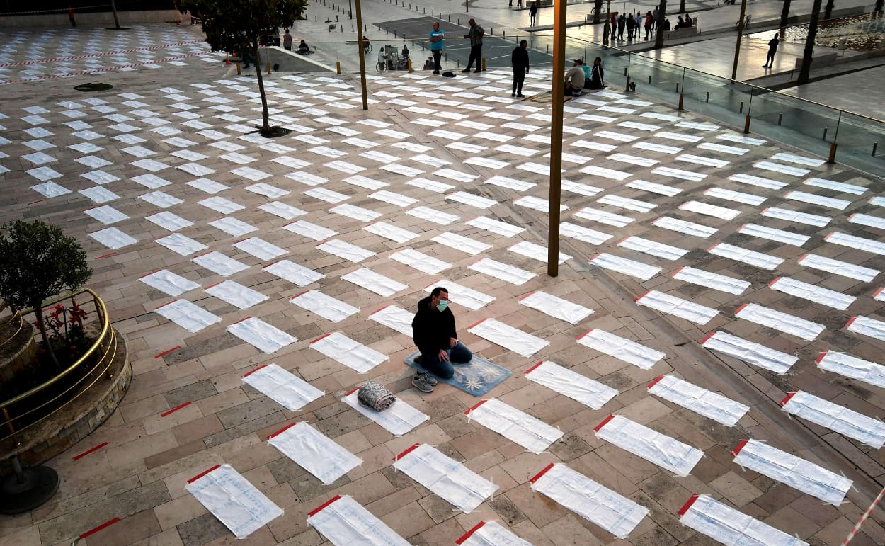 Image: A man wearing a protective face mask prays in a space to enforce social distancing ahead of the Eid Al-Fitr prayer at the Grand Mosque in Durres, Albania, on May 24, 2020.