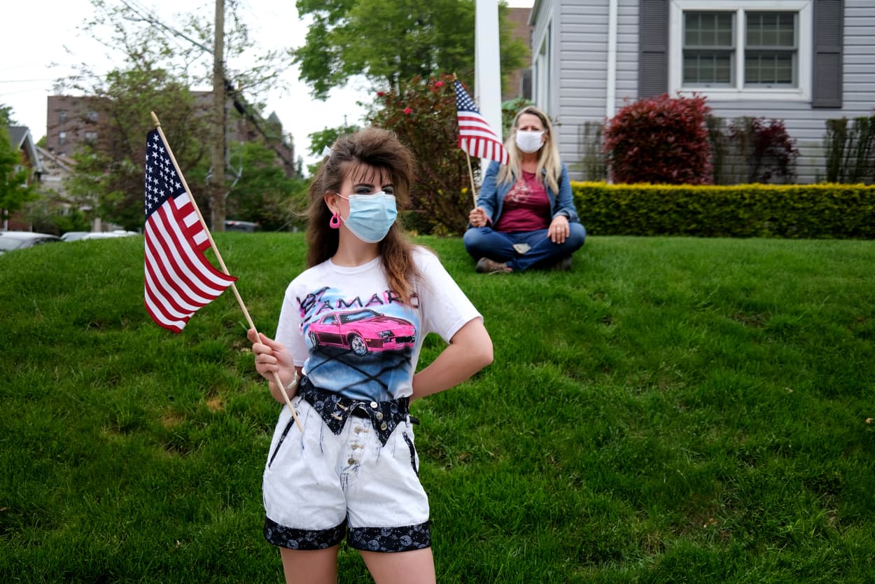 Image: Residents in face masks watch the Memorial Day Parade of motorcycles and cars on Staten Island on Monday.