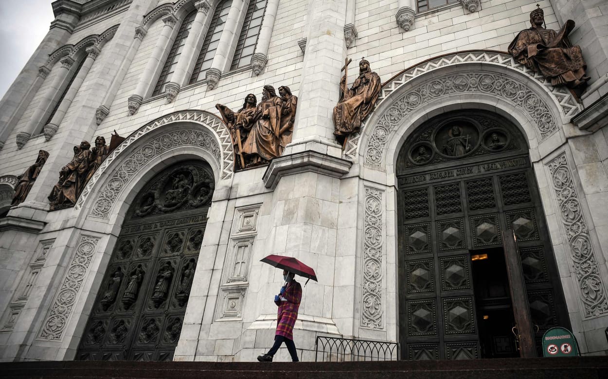 Image: A woman wearing a face mask comes out of Christ-the-Savior cathedral, the main Russian Orthodox church in central Moscow