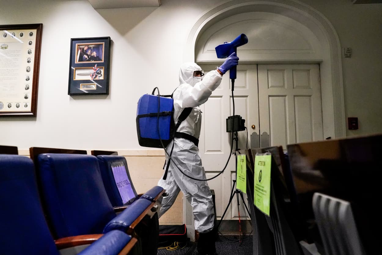 Image: A member of the White House cleaning staff sprays the press briefing room the evening of U.S. President Donald Trump's return from Walter Reed Medical Center