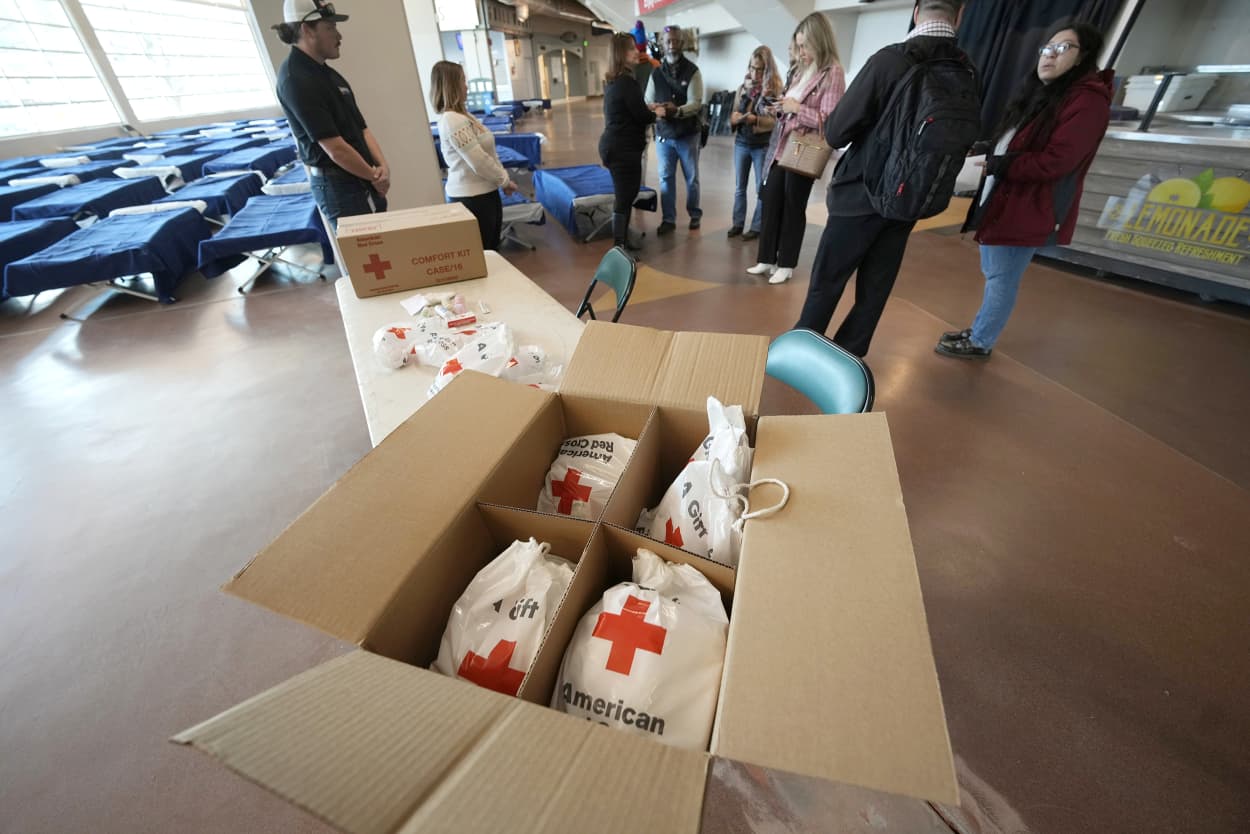 Care bags sit at the ready for people seeking refuge from the intense cold front sweeping over the intermountain West fill the walkways in the Denver Coliseum Wednesday, Dec. 21, 2022, in Denver. The home of the National Western Stock Show and Rodeo will be serving as a warming center until the severe weather abates. (AP Photo/David Zalubowski)