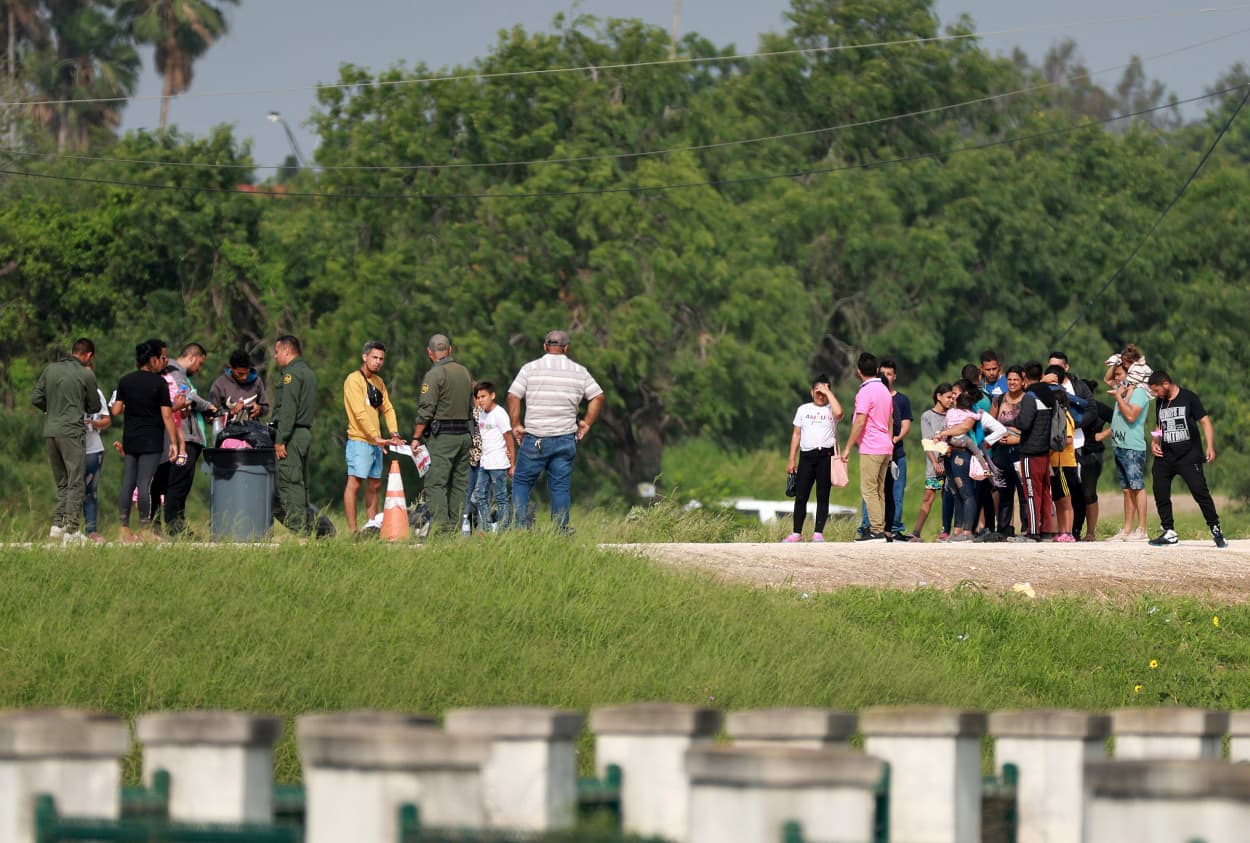 Migrants walk to where the United States Border Patrol is processing them in Brownsville, Texas, after they crossed into the U.S. from Mexico on May 10, 2023.