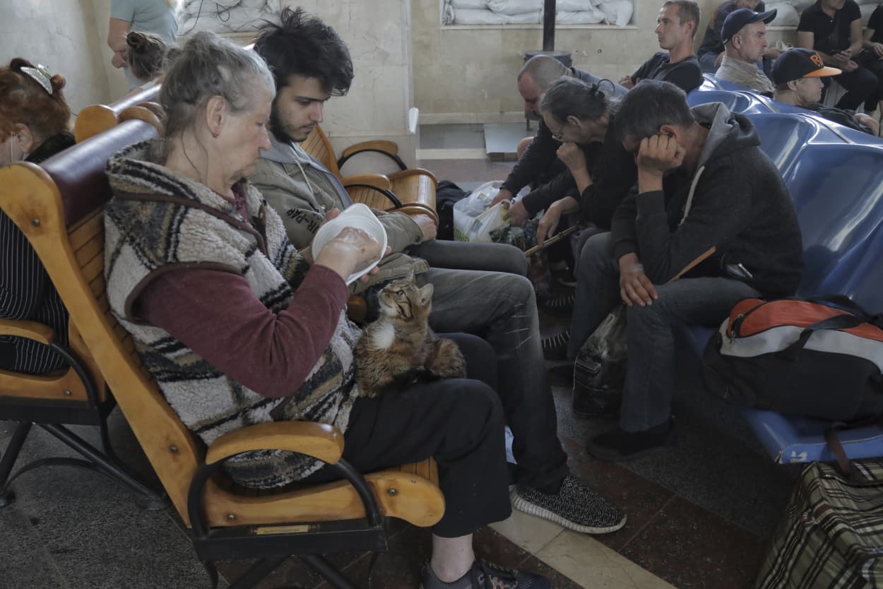 People wait for an evacuation train at a railway station in Kherson