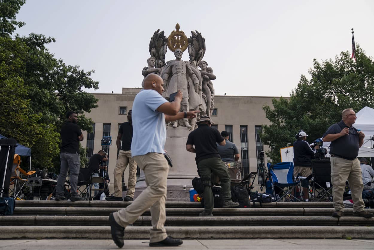 People wait around the George Gordon Meade Memorial outside of the E. Barrett Prettyman United States Courthouse