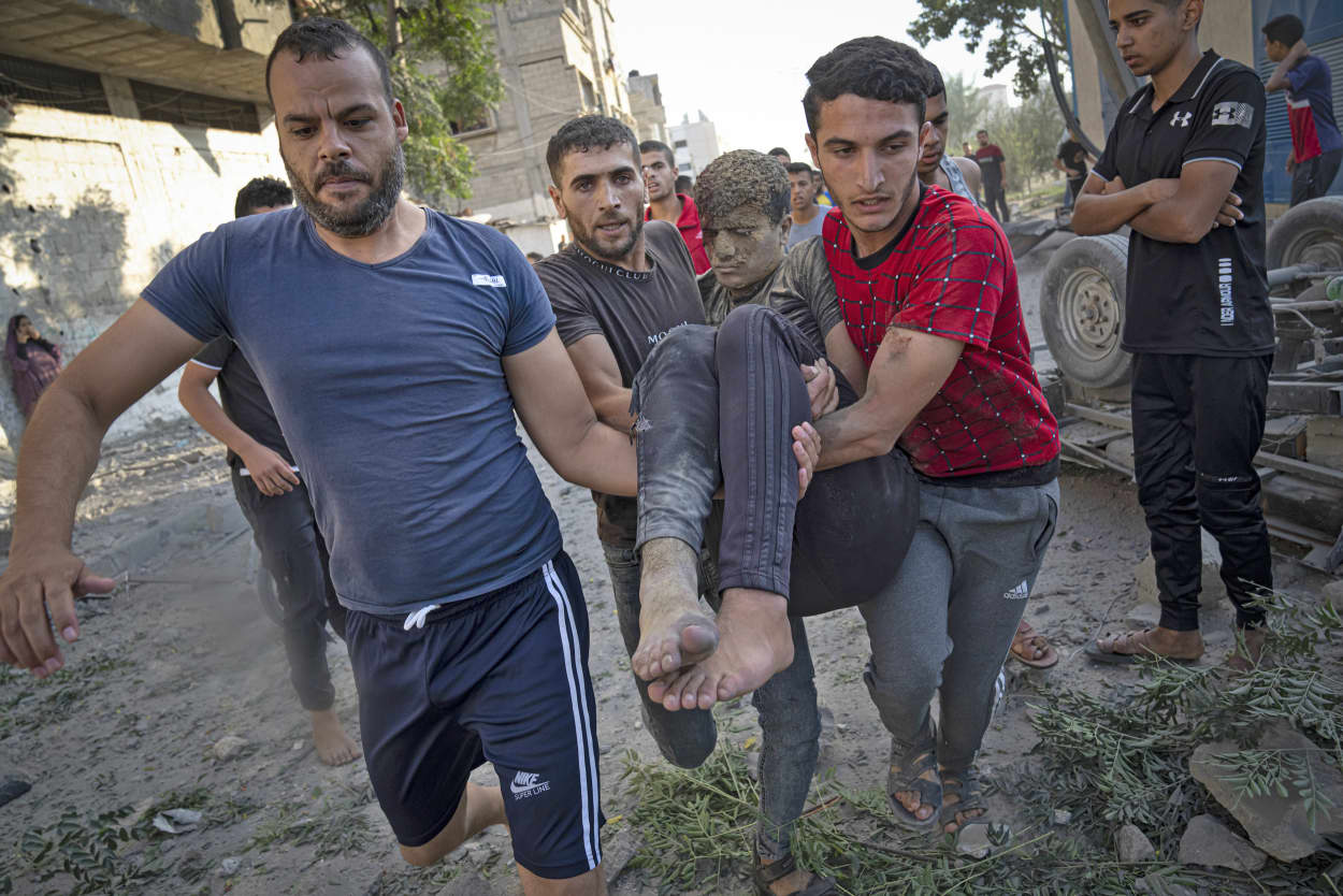Palestinians carry a person wounded in Israeli airstrikes in Khan Younis, Gaza Strip, Monday, Oct. 16, 2023.