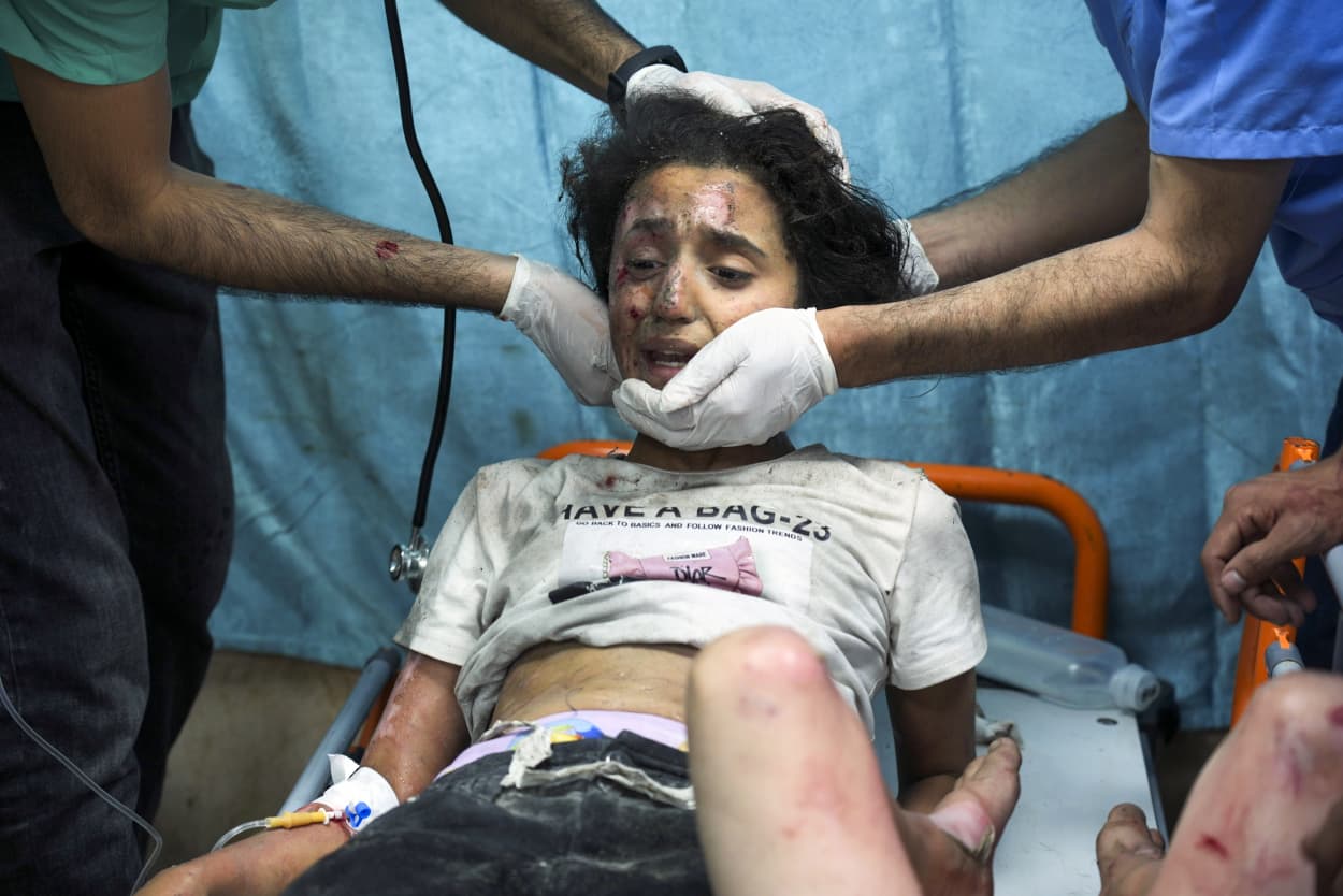 Medical workers treat a child, wounded from Israel's bombardment, at a hospital in Deir al-Balah, southern Gaza.