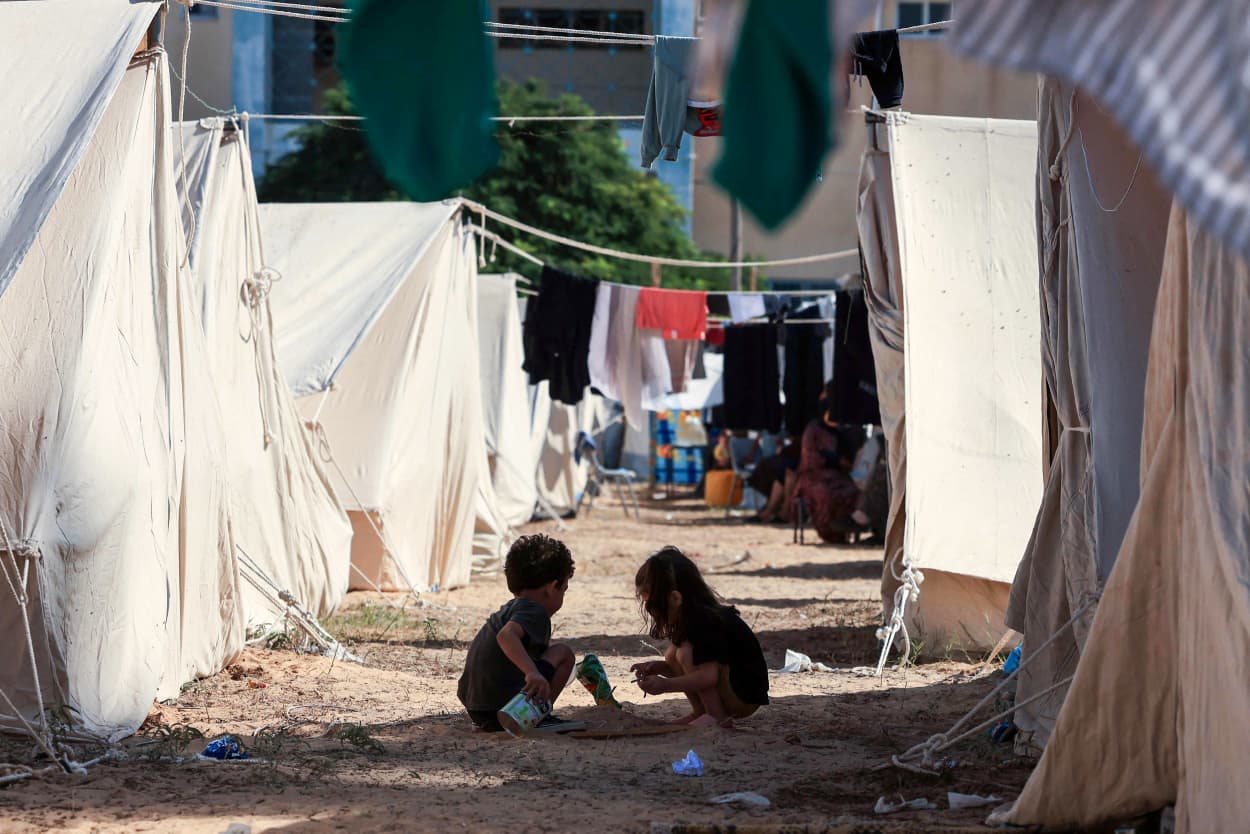 Children play among tents set up for Palestinians seeking refuge on the grounds of an UNRWA centre in Khan Yunis in the southern Gaza Strip.