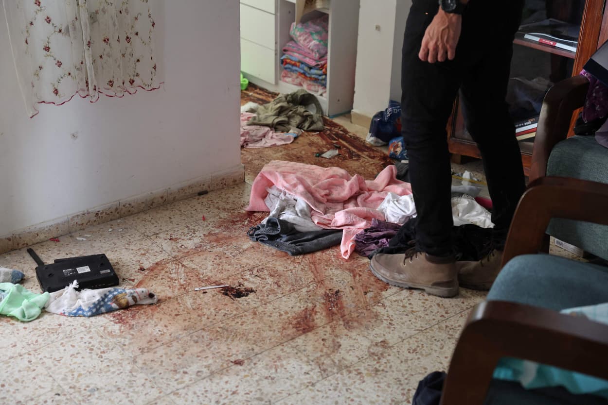 A man checks blood stains on the floor of a house inside the kibbutz Nir Oz along the border with the Gaza Strip on Oct. 19, 2023.
