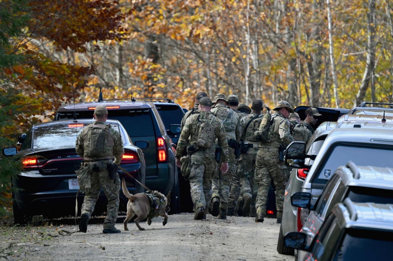 Law enforcement officials search an area near Monmouth, Maine, on Oct. 27, 2023.