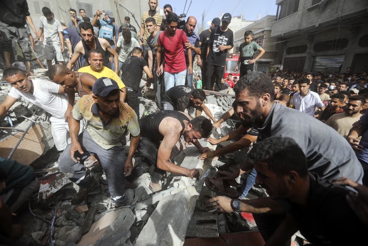 Palestinians look for survivors under the rubble of a destroyed building following an Israeli airstrike in Khan Younis refugee camp, southern Gaza Strip.