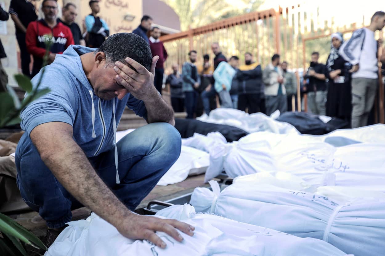 A man cries over bodies of those killed in Israeli airstrikes