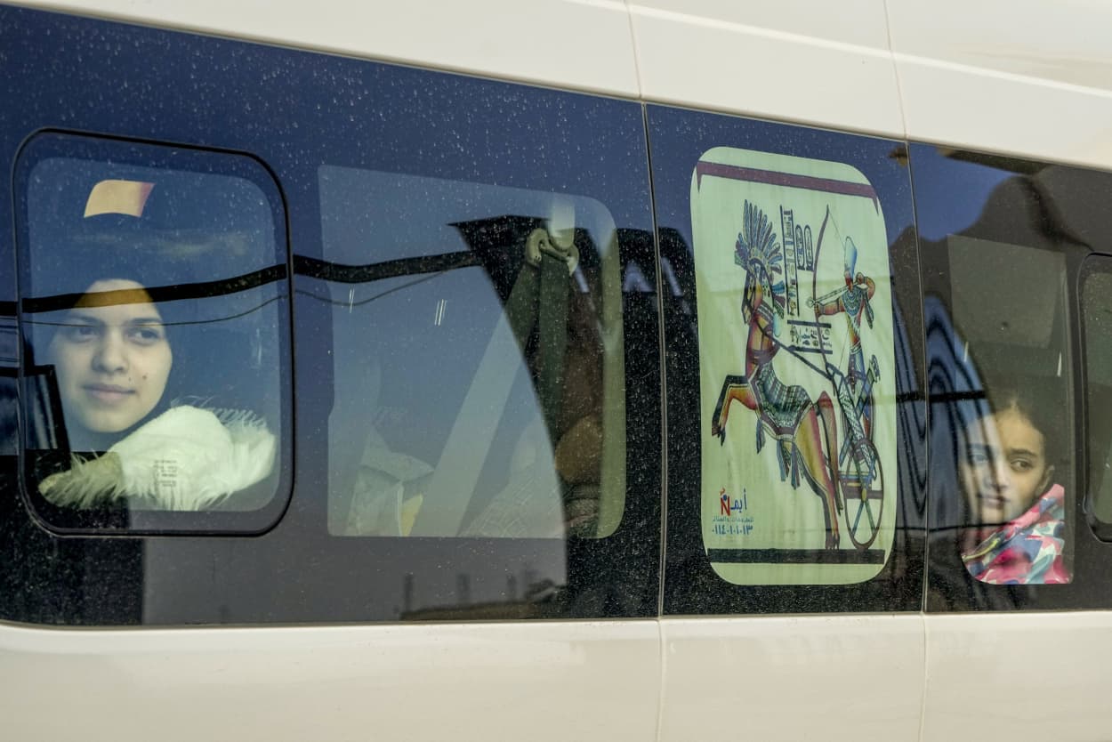 Two young Palestinian girls look out from the windows of a van as they cross from Gaza into Egypt.