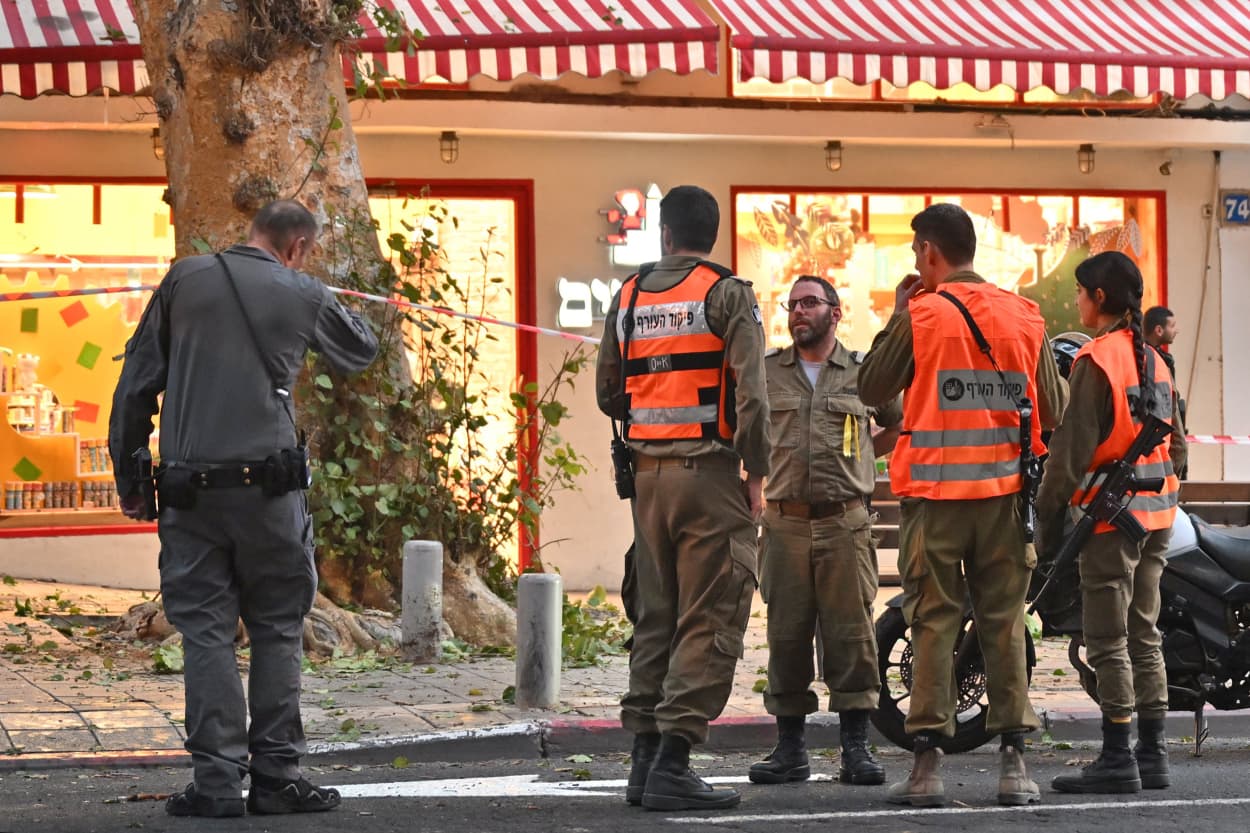 Israeli police and soldiers from the Home Front Command cordon off the area where shrapnel fell after the interception of a rocket fired from Gaza on Dec. 5, 2023 in Tel Aviv.