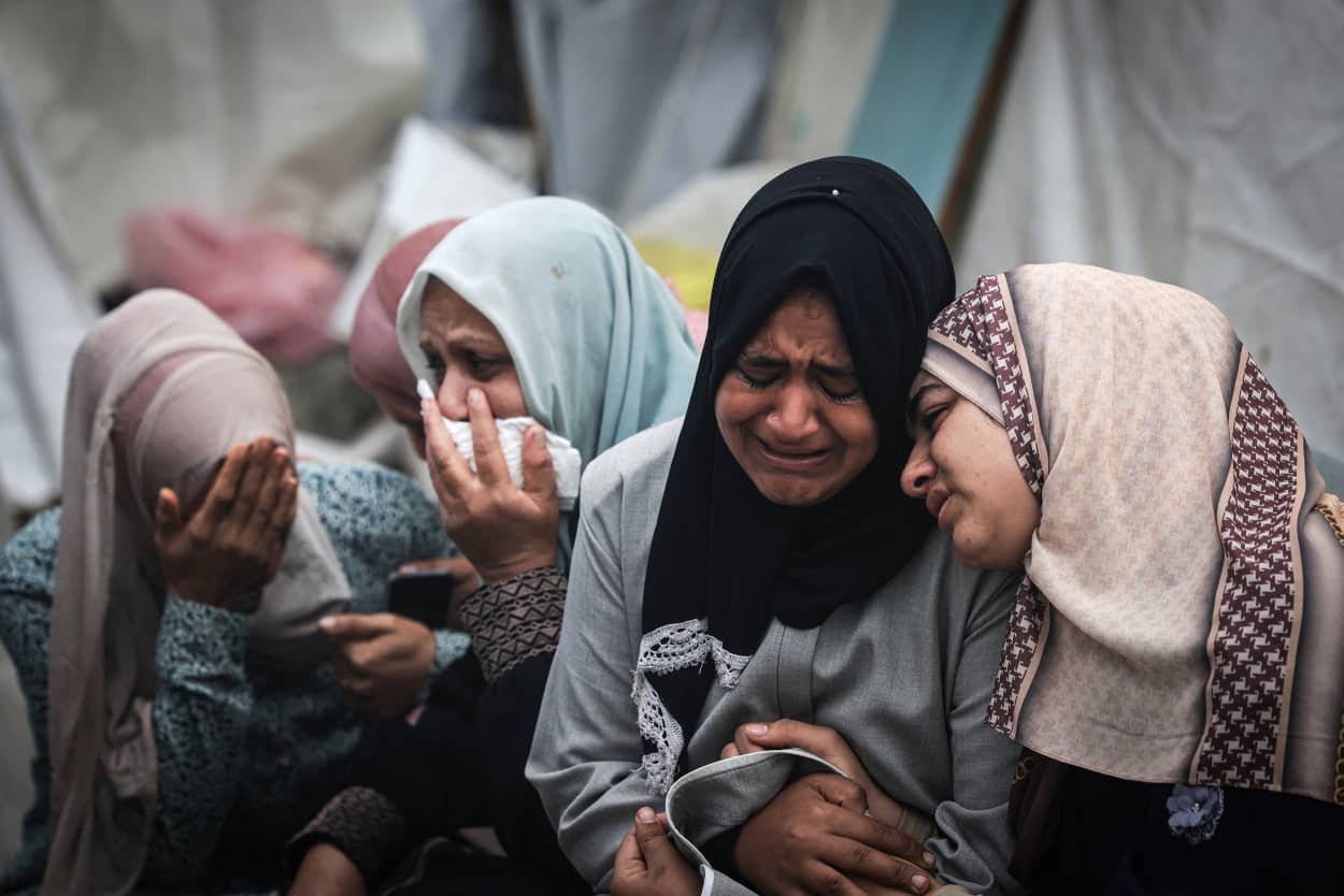 Palestinians mourn their relatives killed at Al-Maghazi refugee camp, during a mass funeral at the Al-Aqsa hospital in Deir Al-Balah