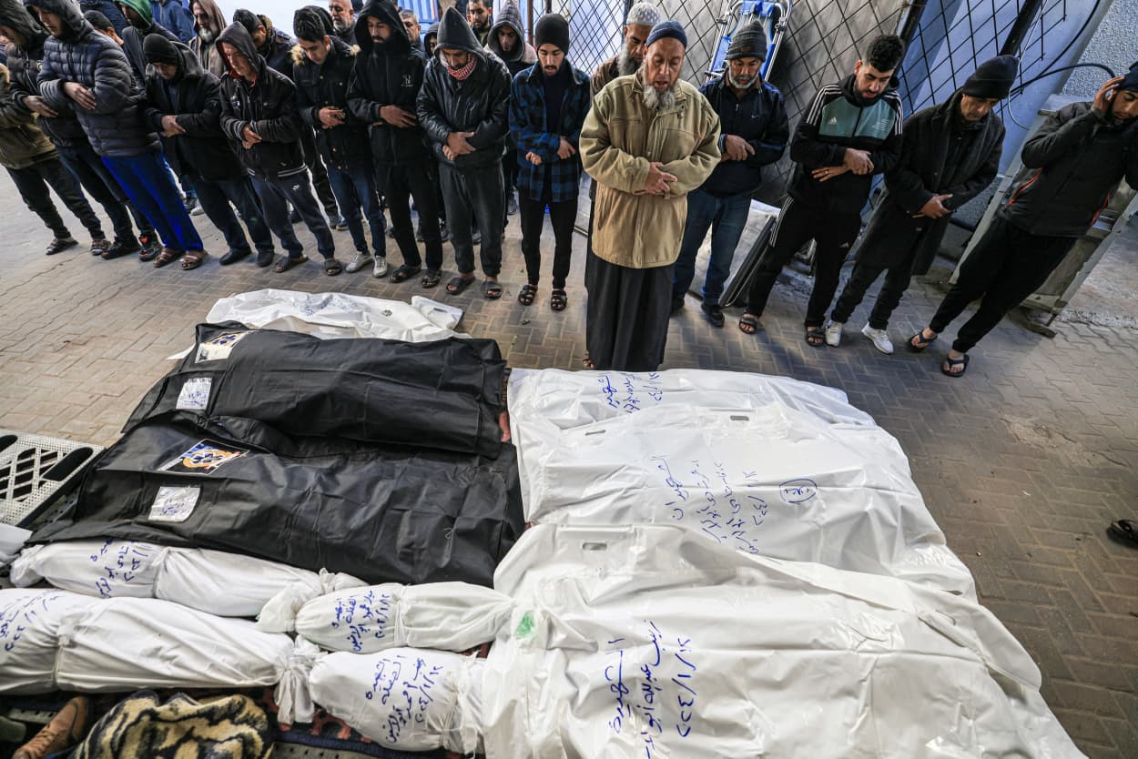 People pray over the shrouded bodies of loved ones on Jan. 13, 2024, at Al-Najjar Hospital in Rafah, southern Gaza.