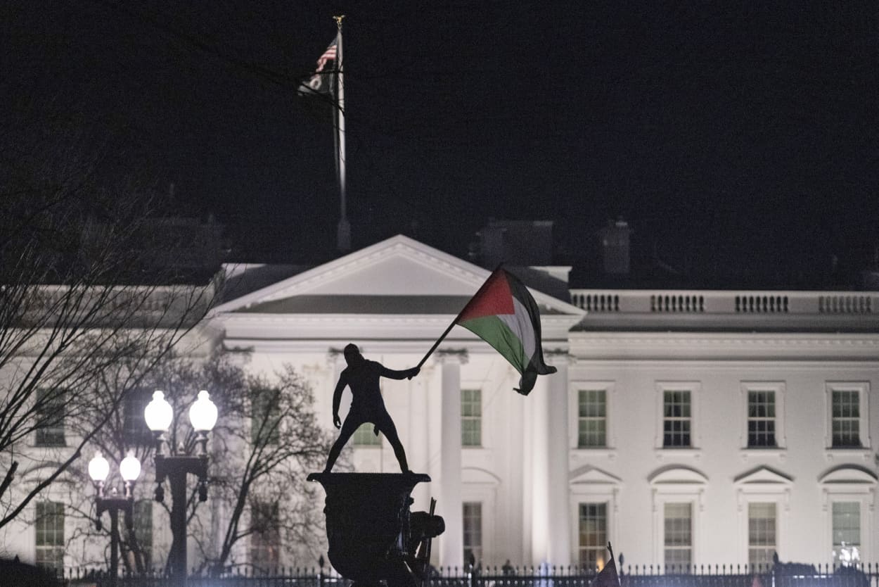 A demonstrator waves a Palestinian flag near the White House during a march for Gaza on Jan. 13, 2024. 