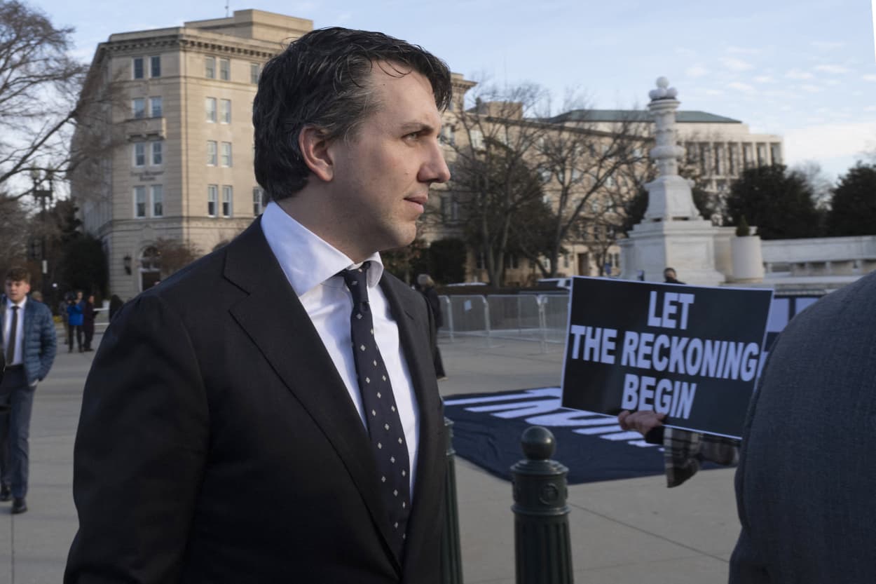 Jason Murray, the lead attorney for the Colorado voters in the lawsuit, walks past anti-Trump demonstrators outside the Supreme Court on Feb. 8, 2024. 