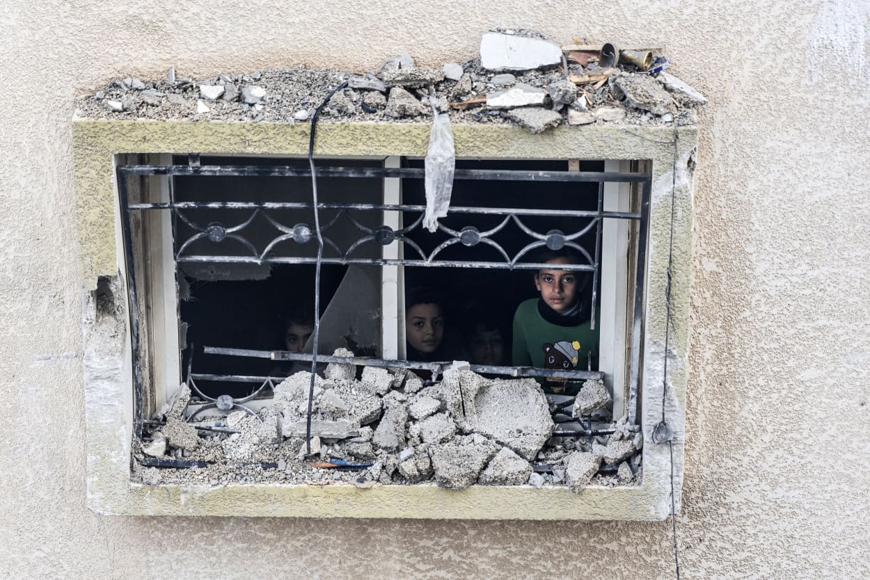 Children look out the window of a damaged building in Rafah, southern Gaza Strip, on Feb. 9, 2024.