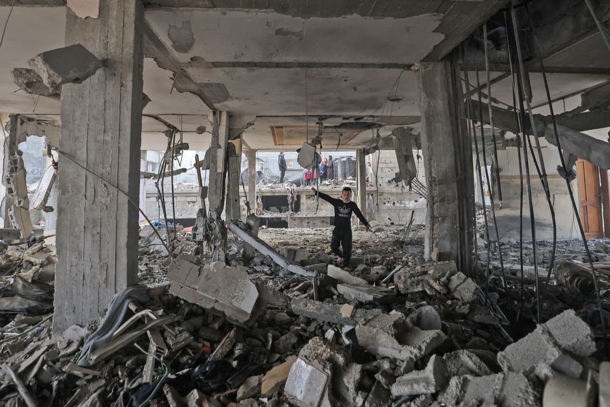A child finds his way through the rubble of a building hit by Israeli bombardment in Rafah in the southern Gaza Strip on February 9, 2024.