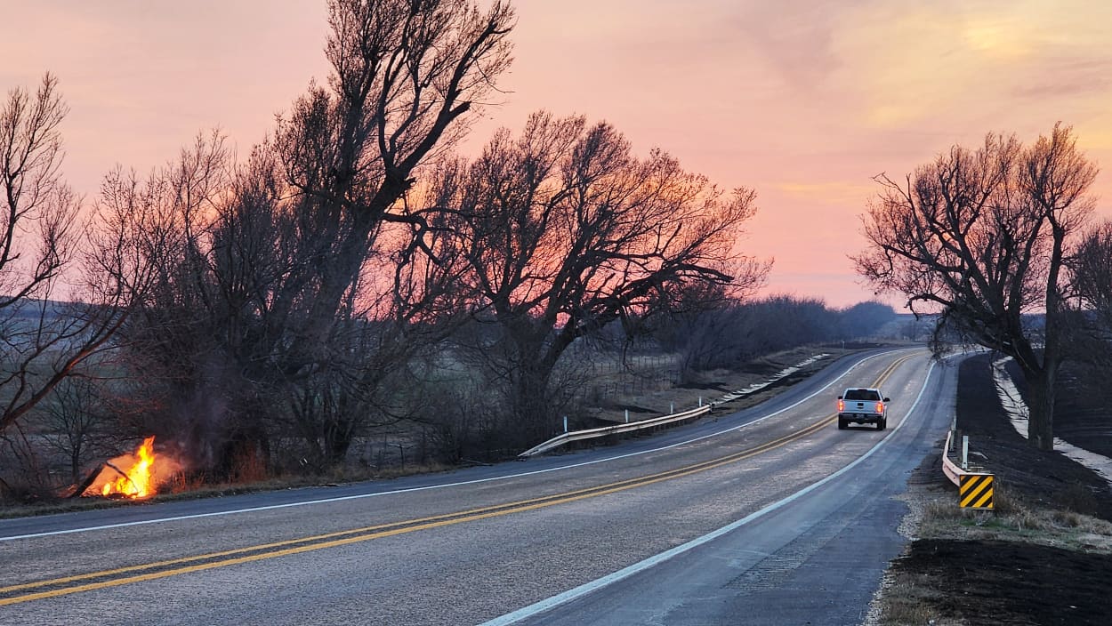 A small fire burns along Highway 33 outside of Canadian, Texas, on Thursday as a remnant of the Smokehouse Creek Fire in