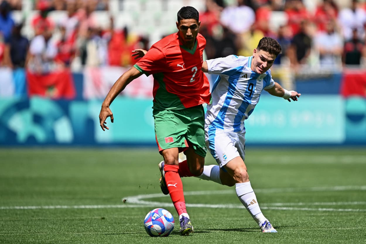 Morocco's defender #02 Achraf Hakimi (L) challenges Argentina's forward #09 Julian Alvarez in the men's group B football match between Argentina and Morocco during the Paris 2024 Olympic Games at the Geoffroy-Guichard Stadium in Saint-Etienne on July 24, 2024.