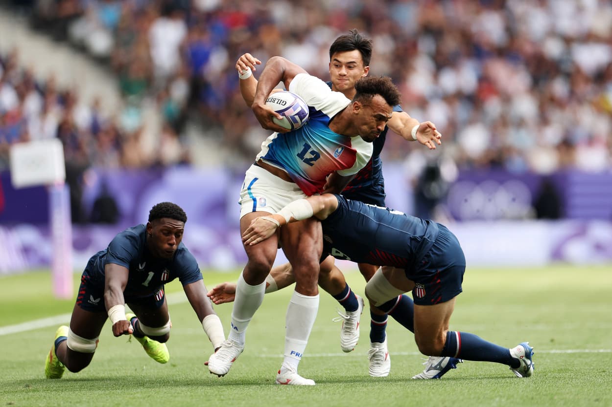 France's Jordan Sepho is tackled during a Rugby Sevens match against United States on Day -2 of the Olympic Games Paris 2024 at Stade de France on July 24, 2024 in Paris, France.