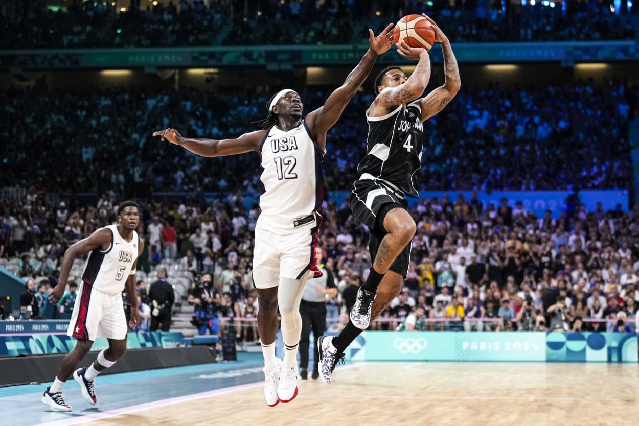 Image: Carlik Jones, of South Sudan, shoots in front of Jrue Holiday, of the United States