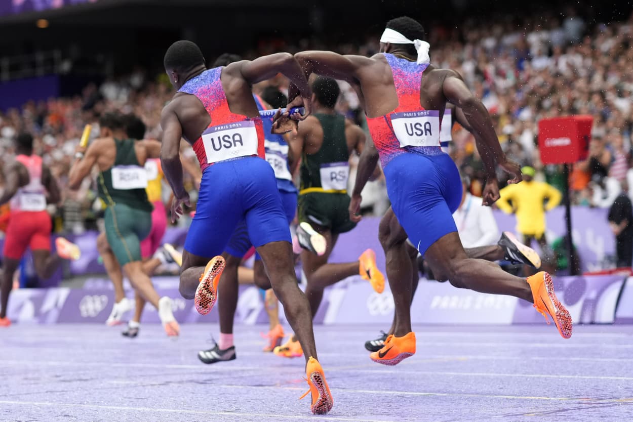 Christian Coleman, left, struggles to hand the baton to teammate Kenneth Bednarek in the men's 4x100-meter relay final at the 2024 Summer Olympics, Friday, Aug. 9, 2024, in Saint-Denis, France.