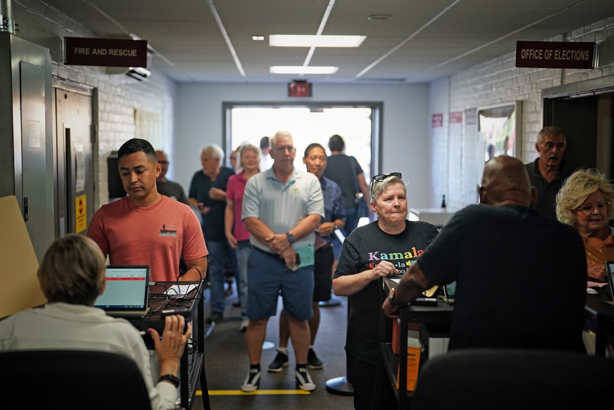 People wait in line to vote on the first day of early voting in Virginia at a voting center in Manassas, Va.