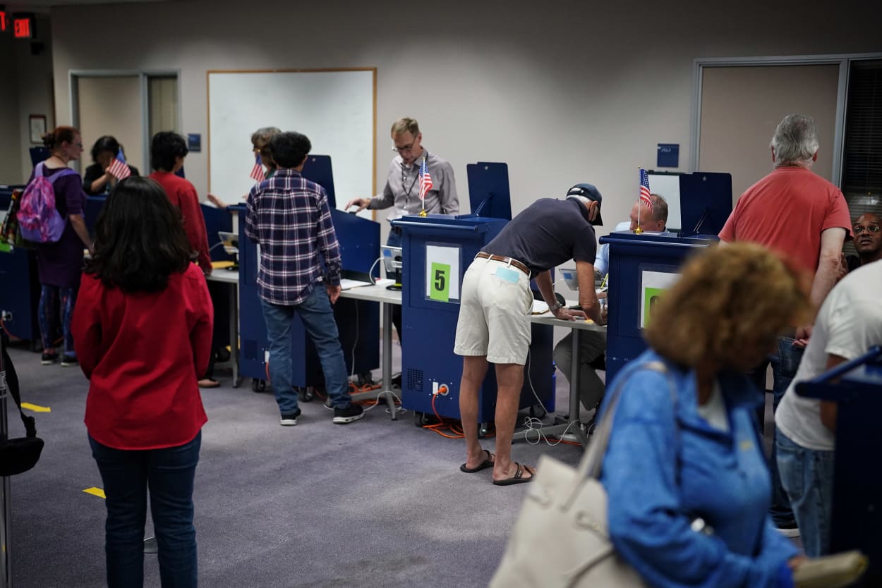 People vote early at on the first day of early voting in Virginia at a voting center in Fairfax, Va. 