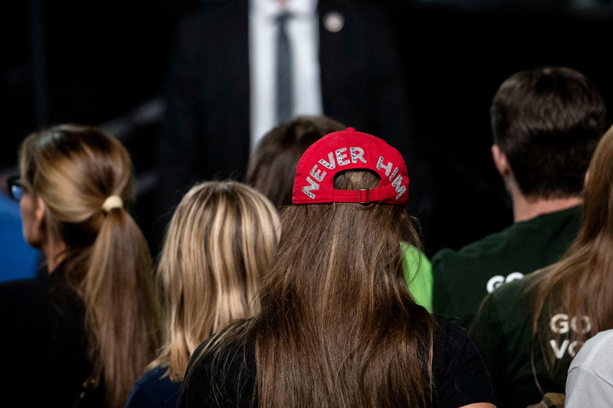 An attendee wears a "Never Him" hat during a campaign event with Vice President Kamala Harris 