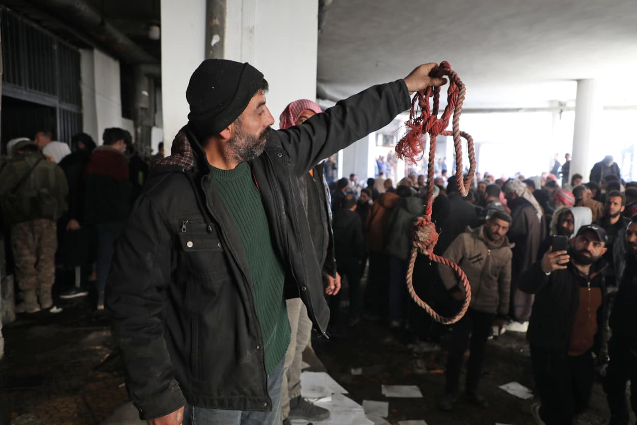 A man holds up rope at Saydnaya prison
