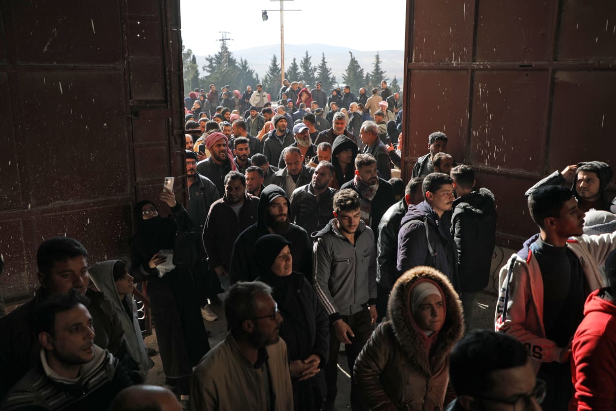 Crowds enter the gates at Saydnaya prison