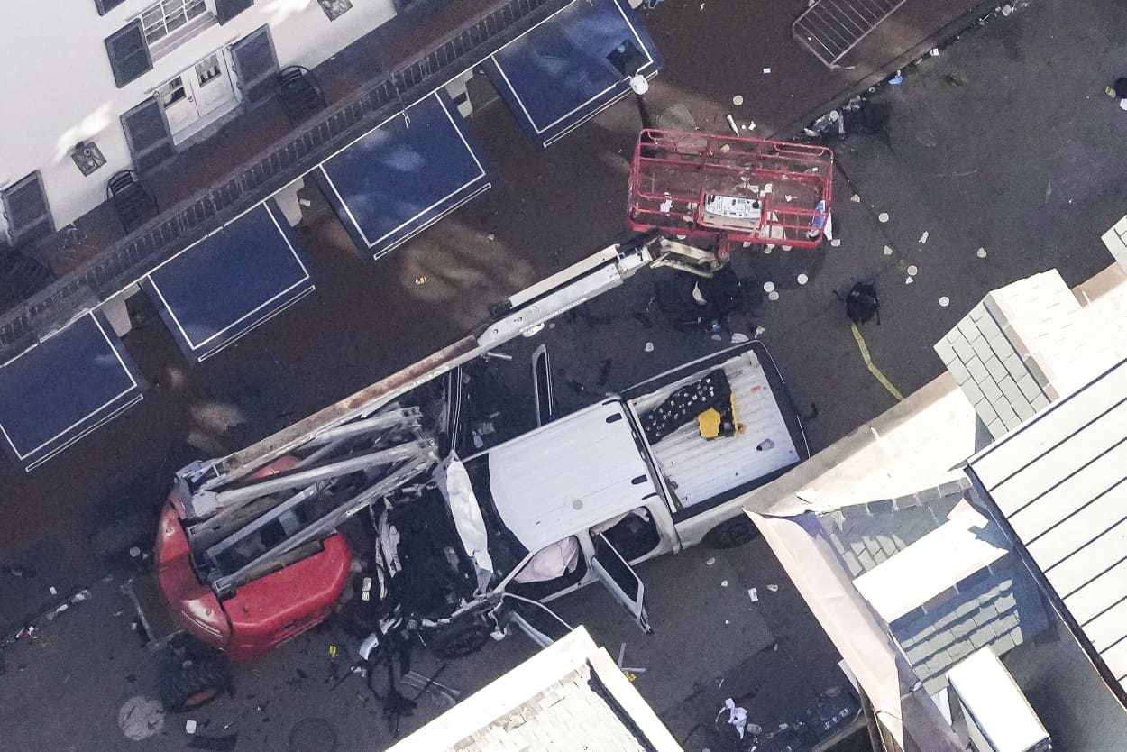 Investigators work the scene after a person drove a vehicle into a crowd