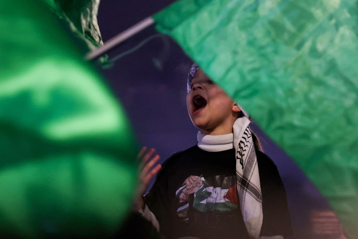 A Palestinian child celebrates as a crowd waves Hamas flags receives some 90 prisoners set free by Israel in the early hours of Jan. 20, 2025 in the occupied West Bank town of Beitunia, on the outskirts of Ramallah.