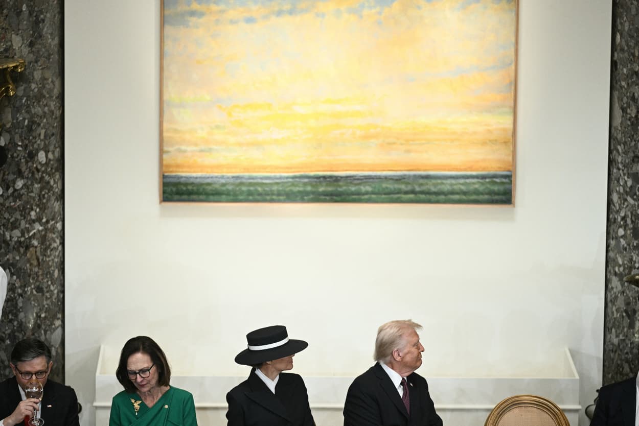 First lady Melania Trump and President Donald Trump sit beneath the painting “American Sky” at the inaugural luncheon. 