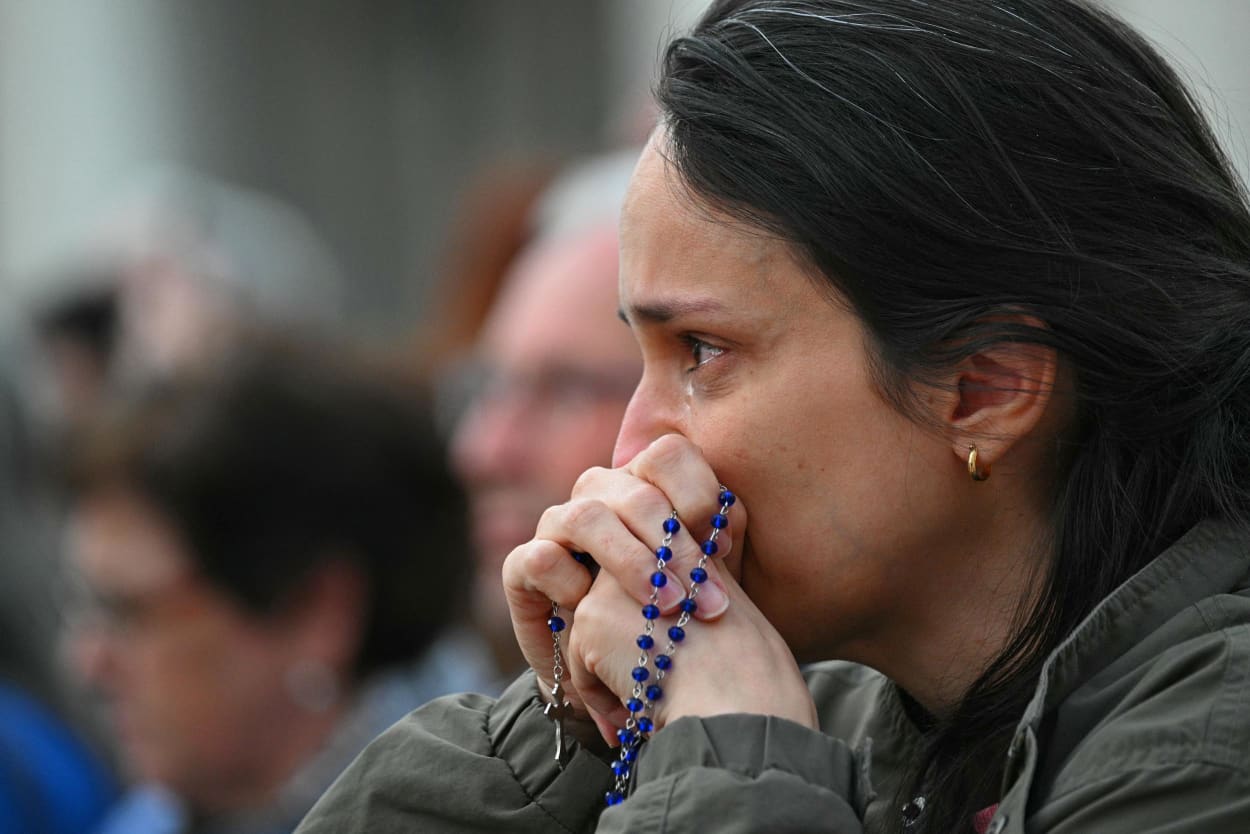 A woman reacts as they hold prayer beads during a Rosary in suffrage to Pope Francis following his death, in Saint Peter's Square, the Vatican, on April 21, 2025. 