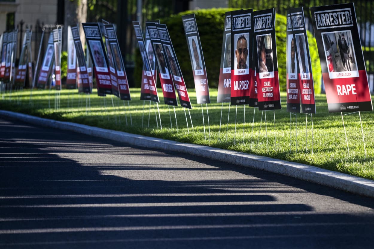 Placards, with the faces of what are described by the Trump administration as alleged illegal immigrant criminals, line the driveway at the White House in Washington, DC, on April 28, 2025. 