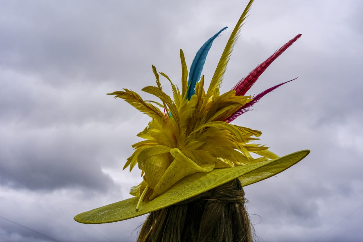 A person wears a hat as storm clouds hang overhead.