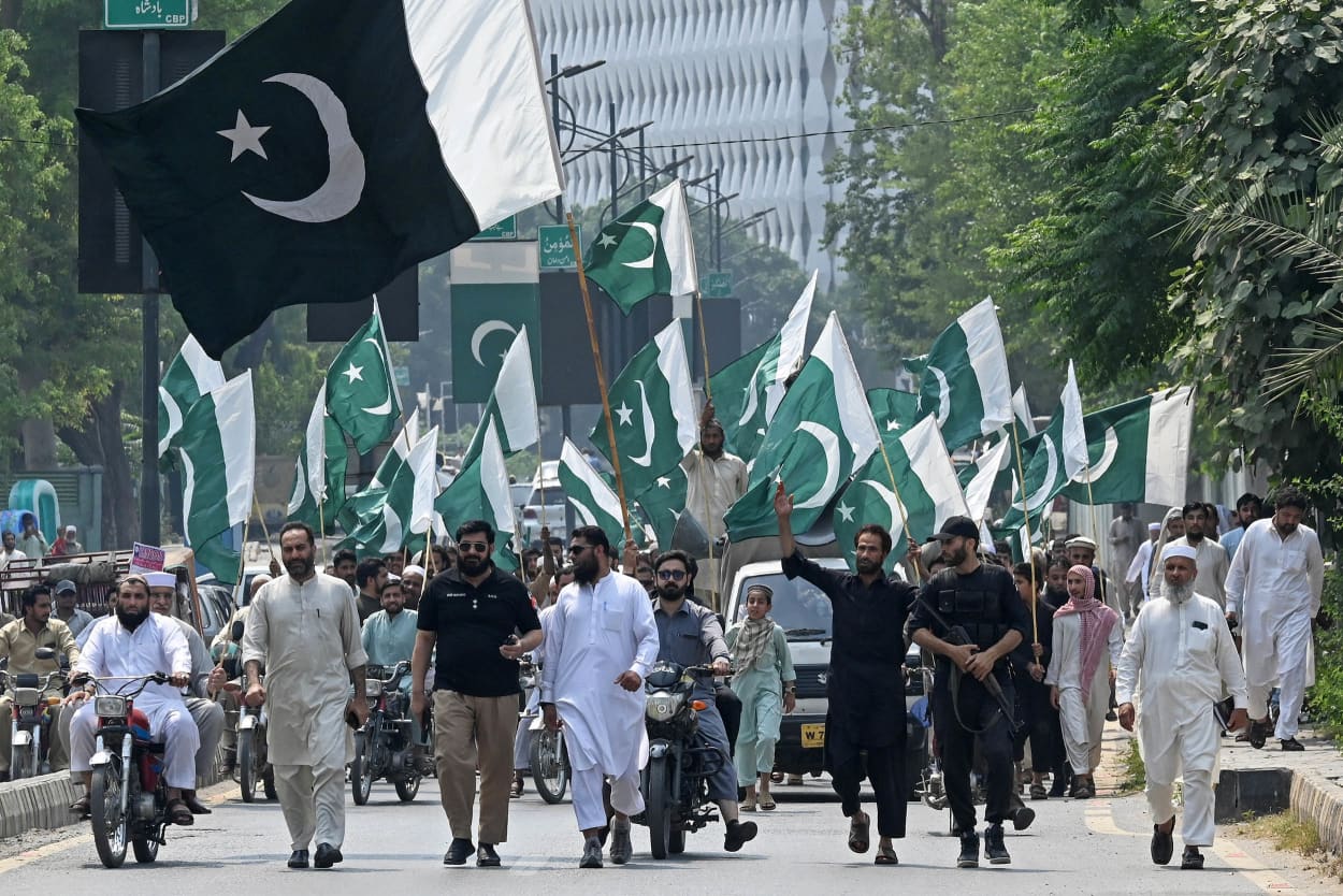 Members of the Pakistan Central Muslim League march in the street as part of an anti-India demonstration in Peshawar.