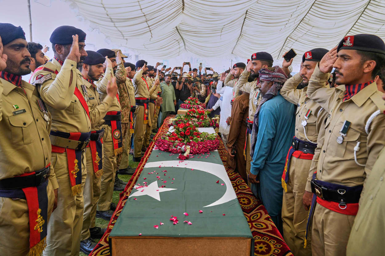 Pakistan army soldiers salute during funeral prayers to the victims of a suspected Indian missile strike incident