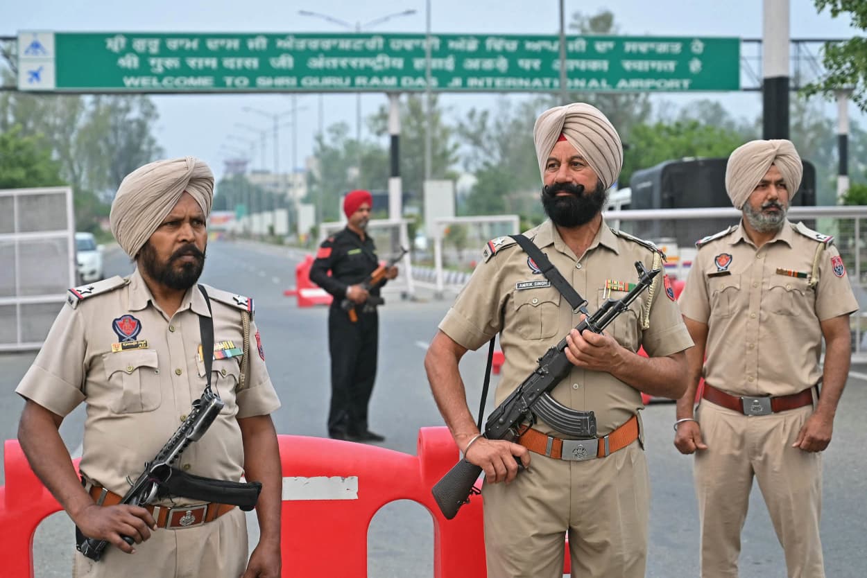 Policemen stand guard on the entrance road of the Shri Guru Ram Das Ji International Airport