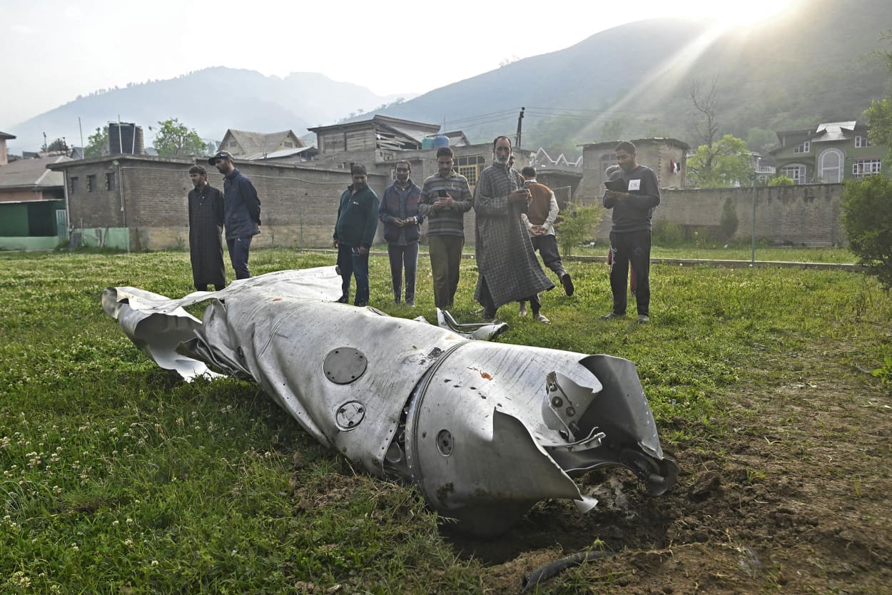 People look at a damaged part of an aircraft in Wuyan, near Srinagar.