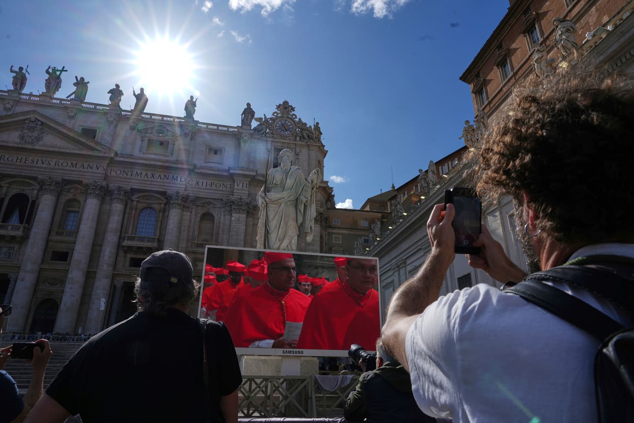 Faithful watch a giant screen showing images of cardinals entering the conclave