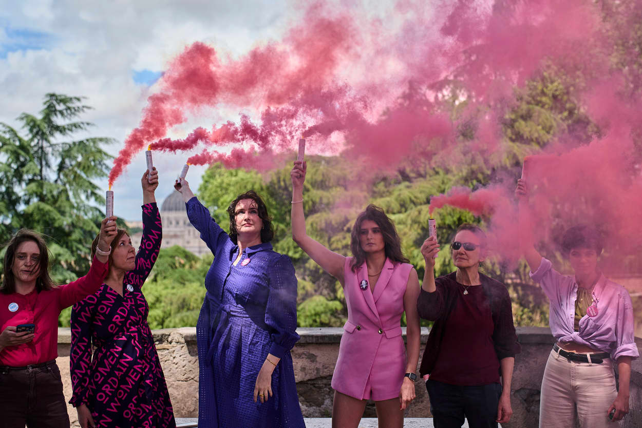Activists from the Women's Ordination Conference release pink smoke 
