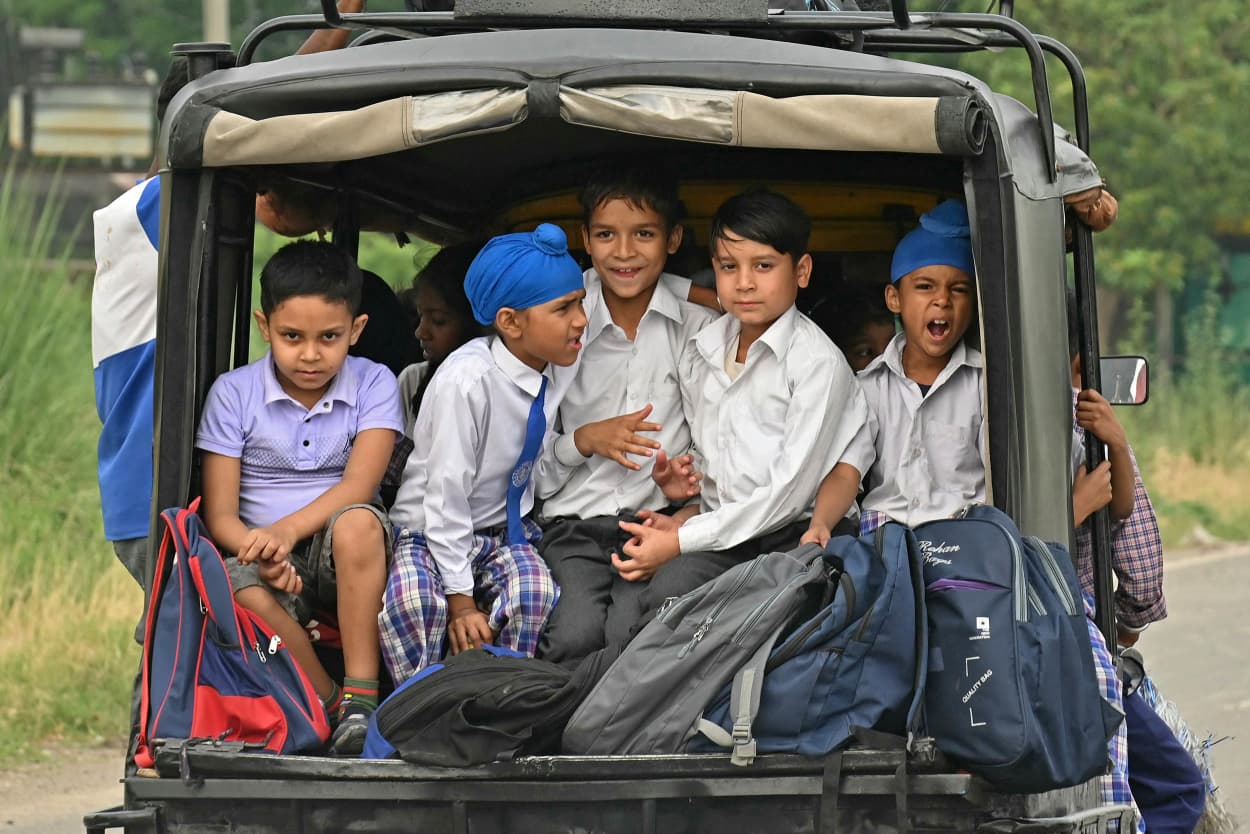 A group of children return back to their homes via vehicle after their schools were closed