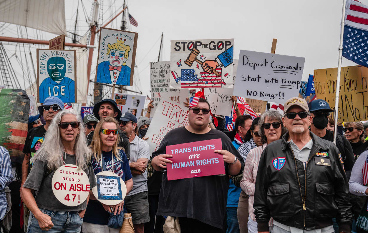 Demonstrators hold anti-Trump signs.