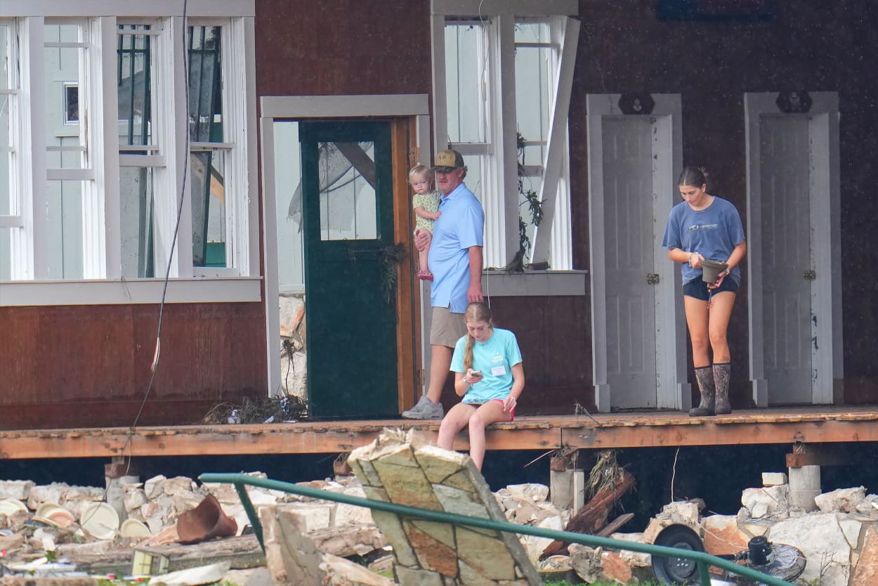 A person salvages a bell from the main building at Camp Mystic along the banks of the Guadalupe River after a flash flood swept through the area Sunday, July 6, 2025, in Hunt, Texas.